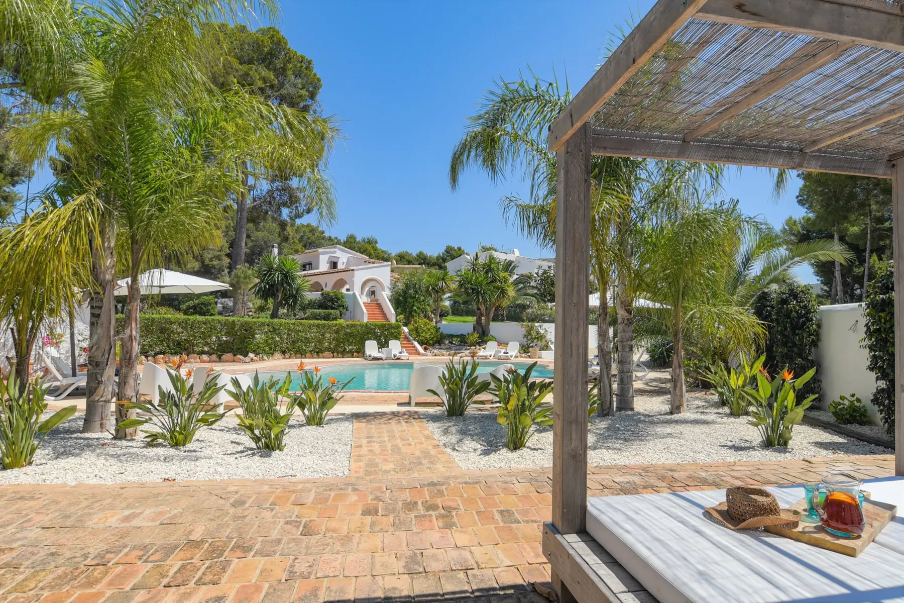 Mediterrane tuin met zwembad en palmbomen in Moraira